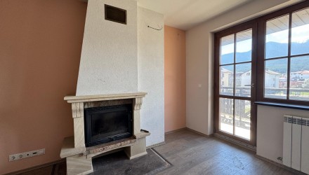 Bright apartment with a fireplace, open-plan kitchen, and balcony with mountain views in a ski resort